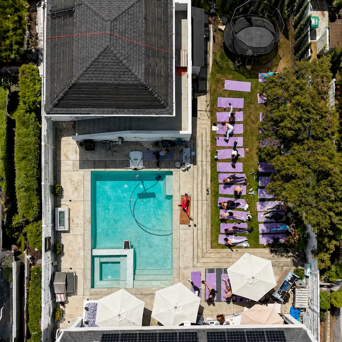 Aerial view of an outdoor venue with yoga mats, pool area, and event setup.