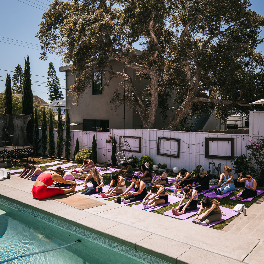 Attendees sitting on yoga mats during an outdoor meditation activity.