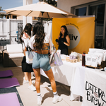 Attendees visiting a vendor booth featuring Date Brew products and event materials.