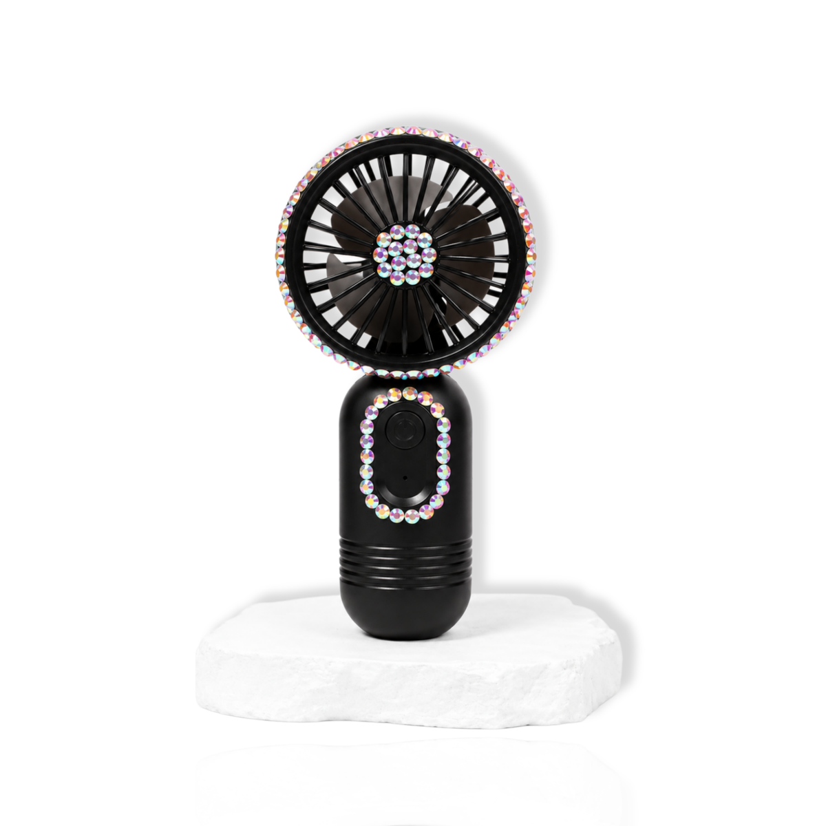 Black portable lash fan with rhinestone detailing displayed on a white stone surface.