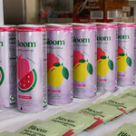 Bloom beverage cans displayed with promotional materials at the event.