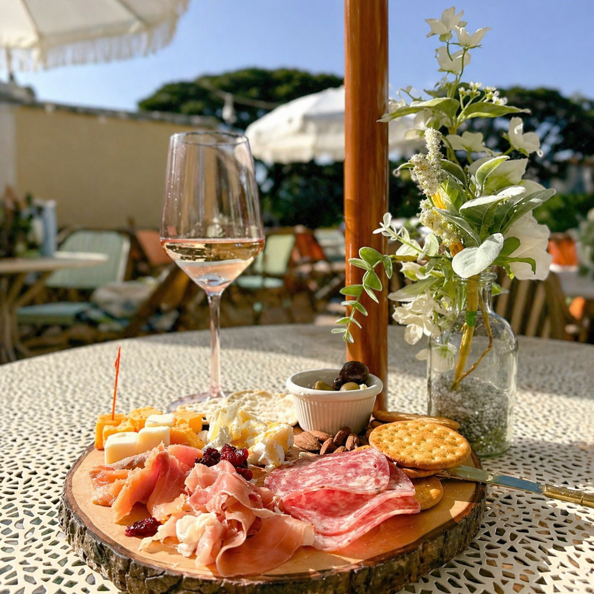 Charcuterie board with cheese, fruit, and wine arranged on an outdoor table at a wellness event.
