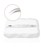 Dolphin curved lash tweezer with angled tip displayed on a white stone background
