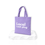 Local Lash Plug purple tote bag for lash artists displayed on a white platform, perfect for carrying lash supplies and beauty essentials