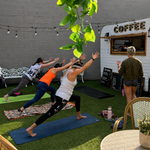 Participants practicing yoga poses during an outdoor stretching session.