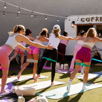 People participating in a group stretching activity during an outdoor fitness session.