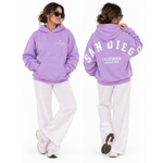 Person wearing a lavender oversized Thousand Lashes hoodie showing the front logo and back San Diego California Lash Con 2026 design.