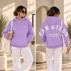 Person wearing a lavender oversized Thousand Lashes hoodie showing the front logo and back San Diego California Lash Con 2026 design