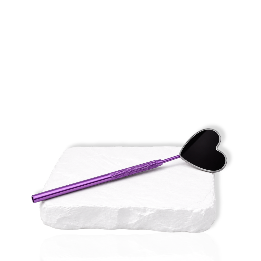 Purple eyelash extension mirror with a black heart-shaped head displayed on a white stone surface.