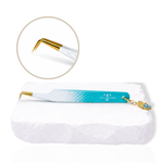 Thousandlashes Evil Eye 90-degree lash tweezer with gold tip and evil eye charm on a white stone surface.