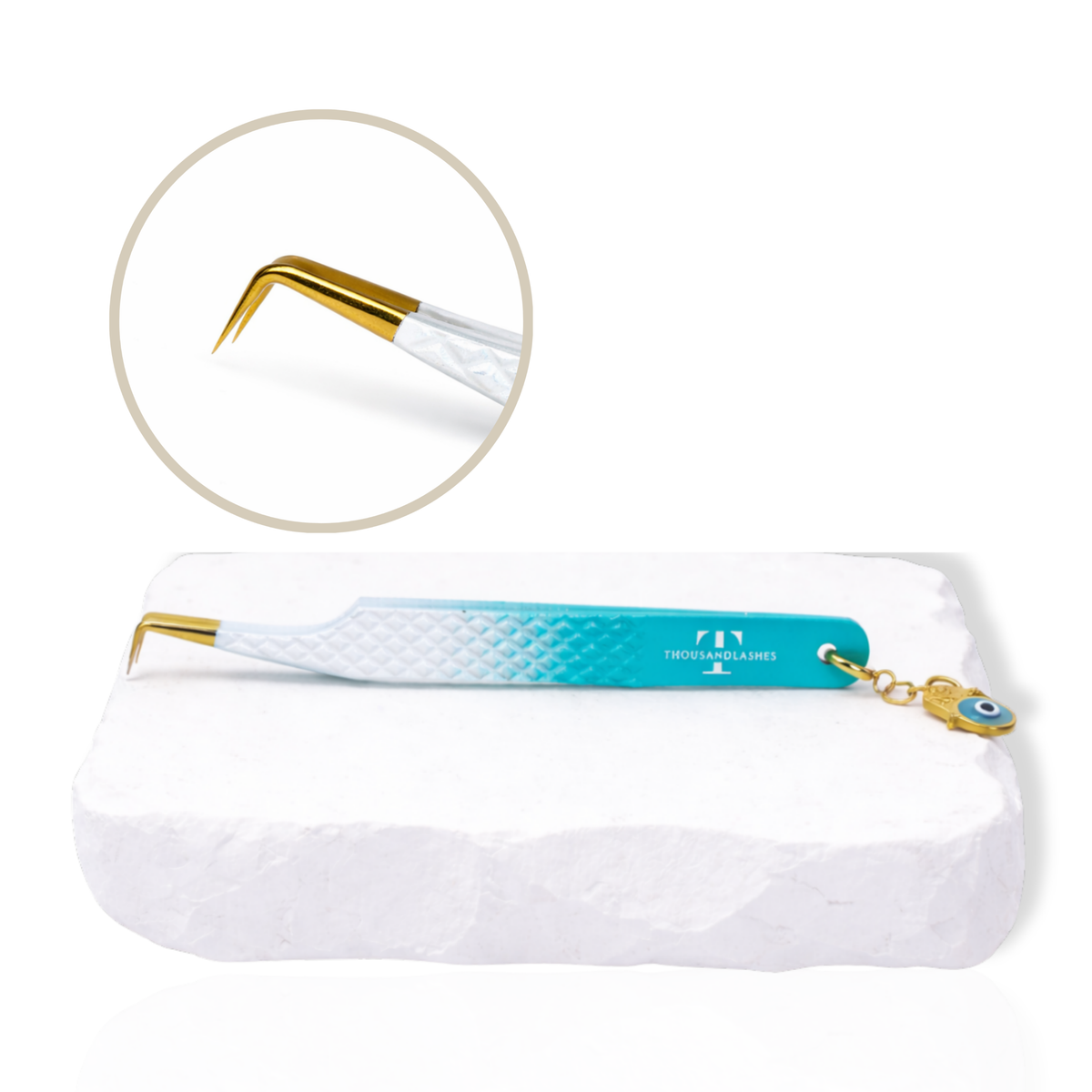 Thousandlashes Evil Eye 90-degree lash tweezer with gold tip and evil eye charm on a white stone surface.