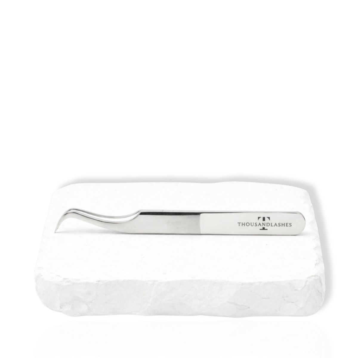 Thousandlashes M Narrow silver lash tweezer on a white stone surface.