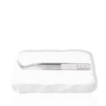 Thousandlashes M Narrow silver lash tweezer shown from the reverse side on a white stone surface.