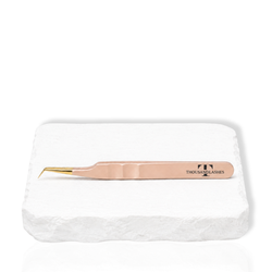 Thousandlashes nude 45-degree isolation tweezer on a white stone surface.