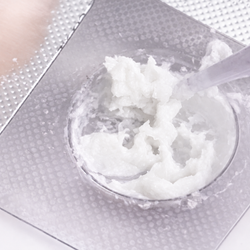 White lash lift mixture being stirred in a clear mixing well.